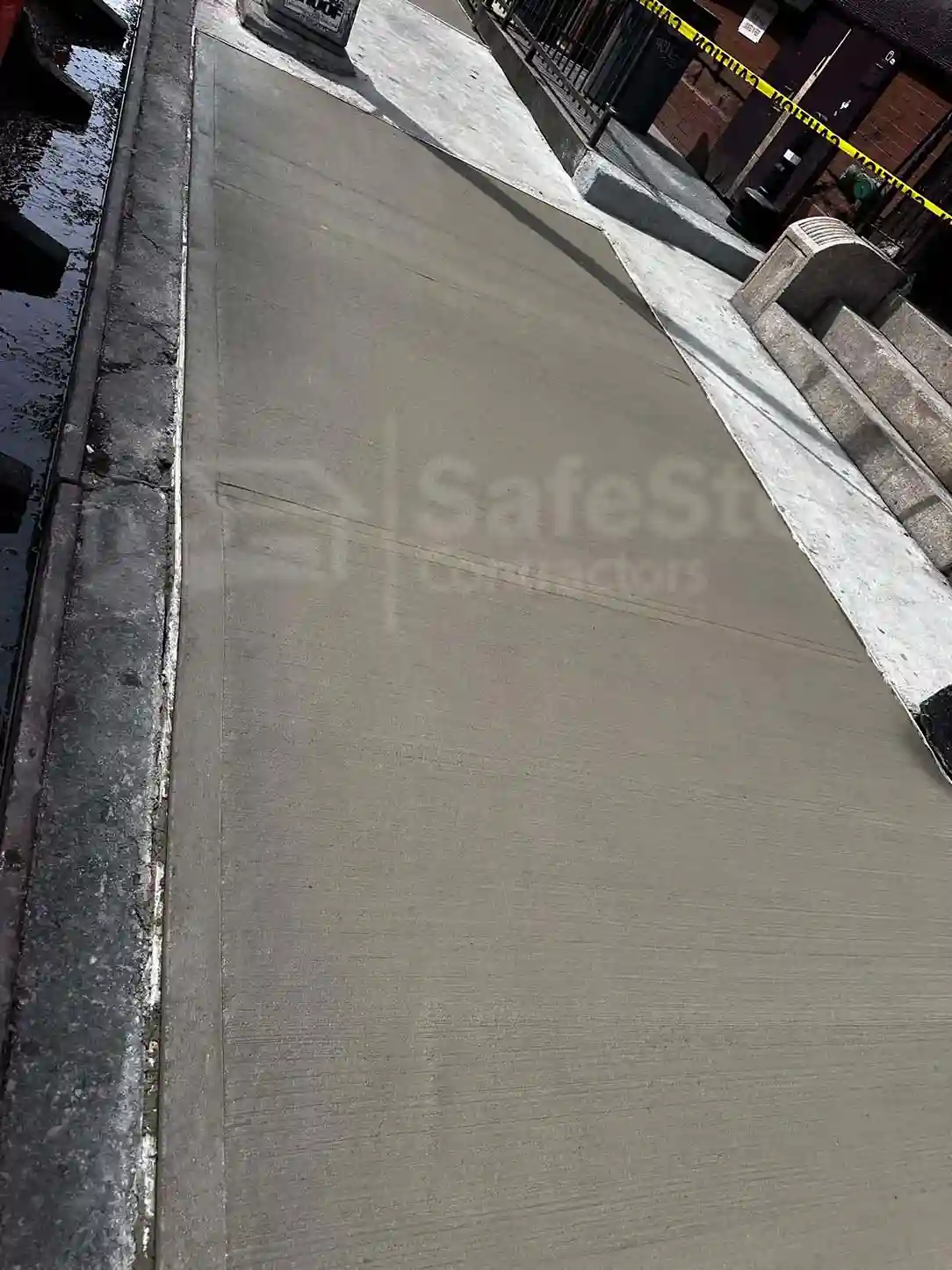 A team of workers repairing a sidewalk with safety cones and tools, ensuring compliance with DOT standards for quality and safety